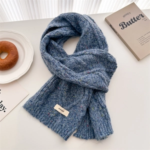 Close-up of navy blue cable knit wool scarf with colorful flecks and brand label
