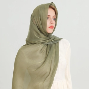 Detail of soft olive green hijab with subtle metallic sheen and lightweight texture