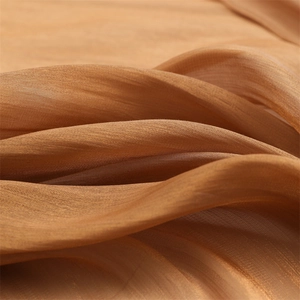 Macro shot of lightweight caramel linen fabric showing soft texture and drapes