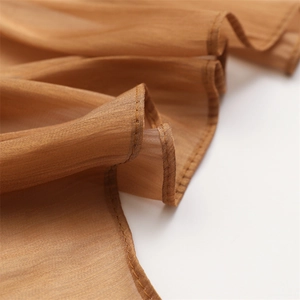 Close-up of high-quality stitching on brown lightweight chiffon scarf fabric