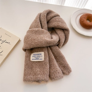 Detail of soft brown knit scarf featuring a vintage textile label on plush wool fabric