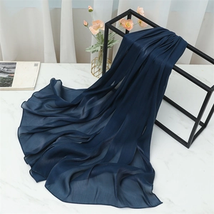Close-up of navy blue lightweight scarf showing fine pleated texture and hem detail