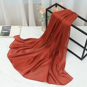 Detailed macro view of pleated terracotta linen scarf with elegant vertical fold texture