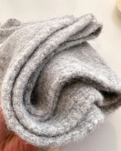 Close-up of soft grey wool knit scarf showing high-quality fuzzy texture and warm fabric