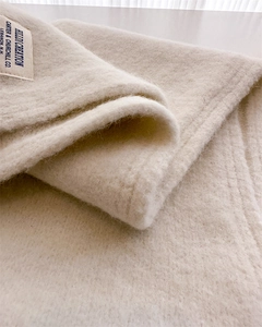 Detailed macro view of soft cream wool knit fabric with vintage woven brand label