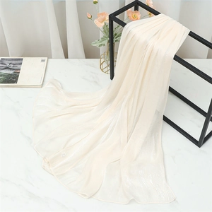 Close-up of cream-colored pleated scarf with pearlescent finish on a metal rack