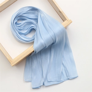 Detail of light blue cotton linen scarf showing vertical pleated texture and silky finish