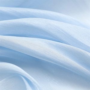 Detail of light blue chiffon fabric with subtle texture and soft pleated folds