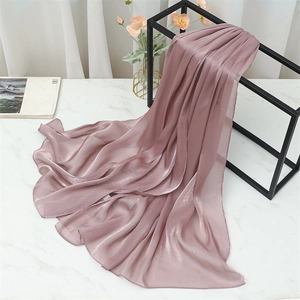 Detail of mauve pleated silk scarf with soft pearl luster on a minimalist stand