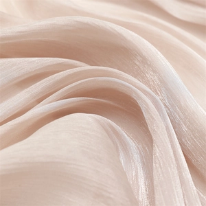 Close-up of champagne silk scarf fabric with elegant soft luster and pleated texture