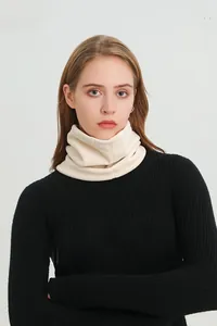 Texture détaillée d'un tour de cou en tricot épais crème porté par un modèle