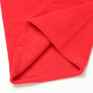 Détail du cache-col en polaire rouge avec texture douce et boutons-pression en plastique