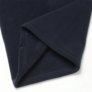 Détail d'un cache-cou en polaire bleu marine avec texture douce et bouton-pression en métal noir