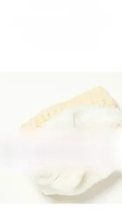 Dettaglio dello scaldacollo in maglia beige con spessa fodera in pile sherpa bianco