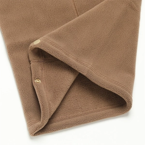 Détail du cache-col en polaire marron montrant la texture douce et le bouton pression