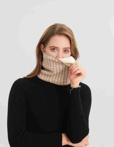 Close-up of houndstooth knit neck warmer with thick white faux sherpa fleece lining
