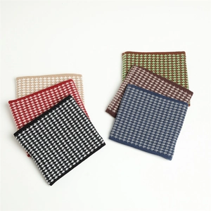 Close-up of thick knitted houndstooth pattern neck warmers in six assorted colors