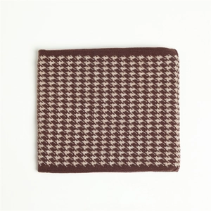 Detailed knit texture of houndstooth scarf in coffee and cream wool blend