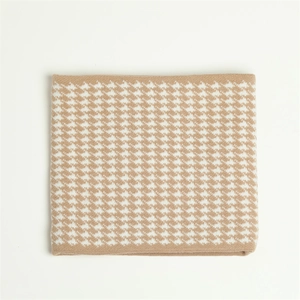 Macro shot of knitted houndstooth pattern detail on warm beige winter neck gaiter