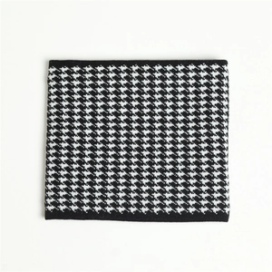 Macro detail of black and white houndstooth pattern on thick knitted neck warmer