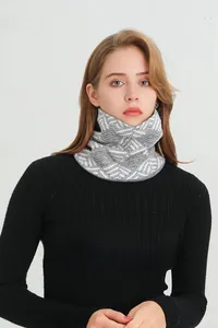 Detail of grey-white chunky knit scarf with fleece lining and geometric jacquard texture