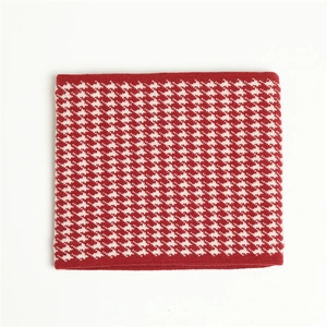 Close-up of red and white dogtooth pattern knit neck warmer with thick texture
