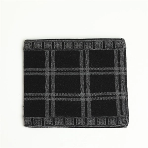 Detailed view of black and gray checkered knit texture on warm winter infinity scarf