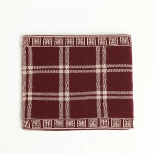 Close-up of thick knit neck warmer in burgundy plaid pattern with geometric edges
