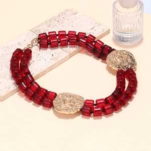 Double-layered beaded necklace featuring red resin beads and gold embossed floral pendants