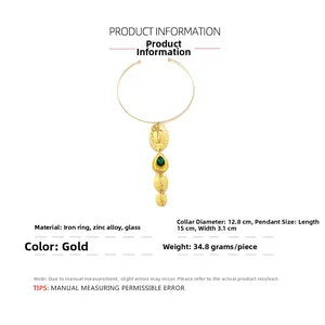 Detail of gold collar necklace showing green glass drop pendant and hammered metal pieces