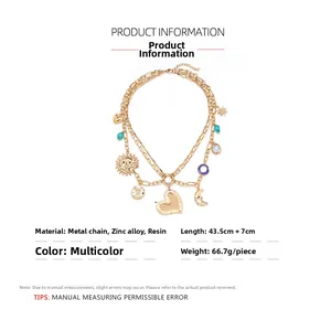Detail of multilayer gold necklace with heart sun and moon charms and resin beads