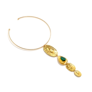 Statement gold choker with hammered metal plates and a teardrop green gemstone pendant