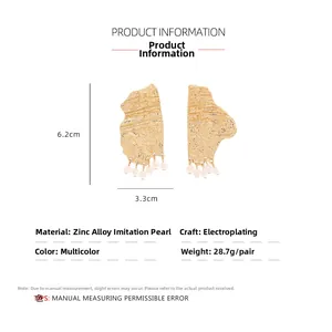 Detail view of irregular gold earrings with imitation pearl drops and size measurements