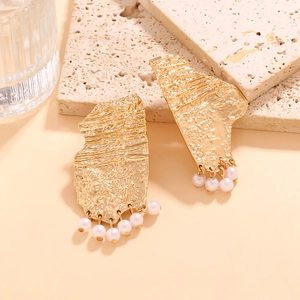 Golden irregular geometric earrings with textured finish and small pearls on stone base