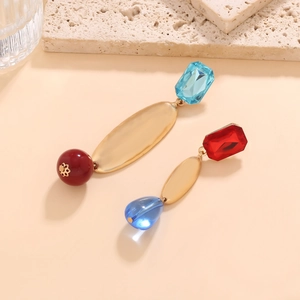 Détail de boucles d'oreilles longues asymétriques avec métal et perles de résine colorées