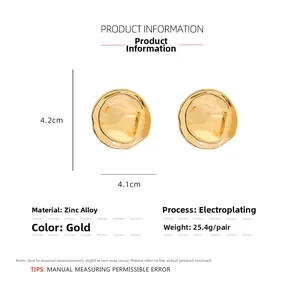 Gros plan de boucles d'oreilles géométriques dorées avec détails de taille et de poids