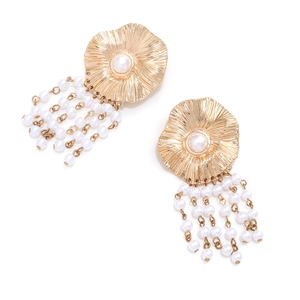 Close-up of golden flower earrings featuring central pearl and delicate pearl tassels