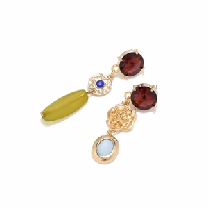 Detailed macro view of asymmetric vintage earrings with gold flowers and colorful stones