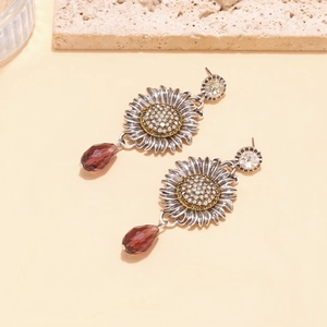Detailed close-up of retro silver sunflower earrings with sparkling purple crystal drops