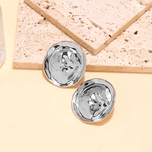 Gros plan de boucles d'oreilles géométriques argentées avec finition métal froissé