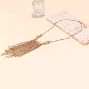 Detail of bohemian gold multi-strand ball chain tassel necklace with lobster clasp