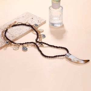 Retro multilayer necklace with heart, coin charms and textured horn pendant on stone surface