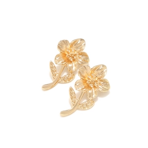Detailed close-up of golden alloy flower earrings with textured petals and curved stems