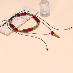 Close-up of ethnic beaded necklace with resin charms and carved silver spacers on stone