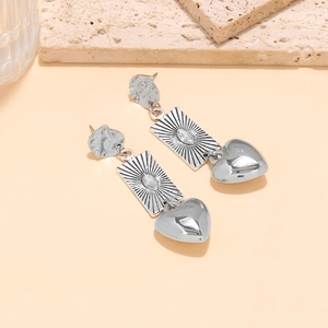 Vintage silver tiered earrings with geometric coin textures and heart-shaped pendants