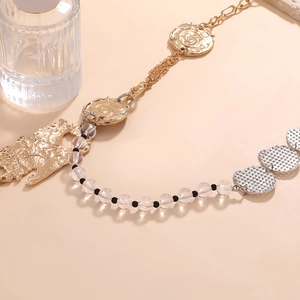 Détail du collier de perles rétro avec pendentif pièce florale dorée et breloques géométriques