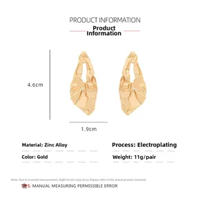 Detailed view of gold irregular textured earrings with size measurements 4.6cm and 1.9cm