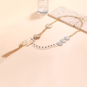 Vue détaillée du collier bohème avec pendentifs pièces, franges dorées et perles ciselées