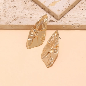 Close-up of gold hollow irregular geometric earrings with vintage crumpled texture metal