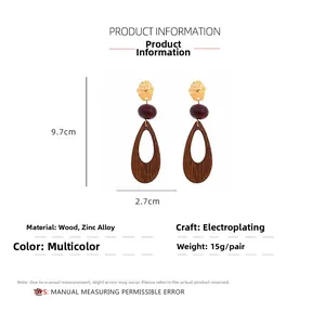 Detailed view of geometric hollow wooden teardrop earrings with dimensions 9.7cm by 2.7cm